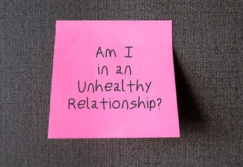 Pink note on wallpaper with text written Am I in an Unhealthy Relationship? - means relationship which partner or family member shows abusive behaviour disrespectful, controlling or violent