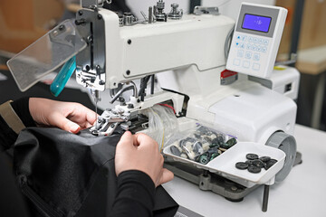Woman working with sewing machine in professional workshop, closeup