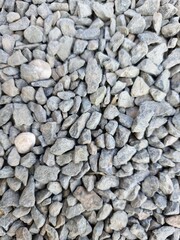 Small piles of stones or gravel, with gray and white congruence, these stones are of an uneven shape.