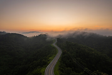 Beautiful sunrise over the mountains and winding rural roads in Thailand.