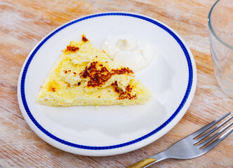 There is piece of casserole on plate, made from cottage cheese, sugar and vanilla. Traditional sweet diet snack, Russian cuisine