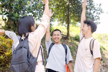 Multiethnic Group Of Asian Students Raising Hands While Learning Outdoor Together