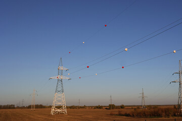 The colored plastic balls hanging on overhead electricity wires are called aerial marker balls, and...