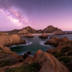 Milky Way shines over a secluded beach and rocky coastline at night.