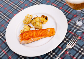 Salmon fillet with cauliflower on a white plate. Serving delicious salmon with sparkling wine