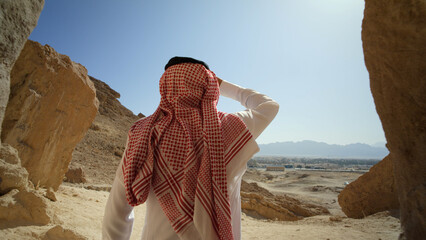 Saudi Arabian man staring out at beautiful desert landscape