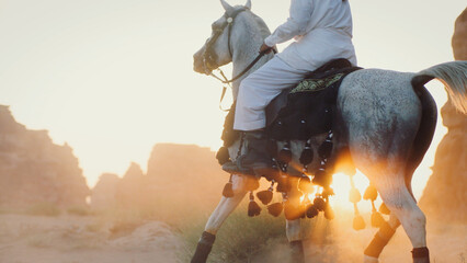 Saudi Arabian man riding majestic white stallion at sunset