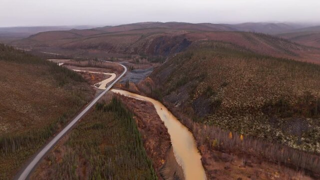 Dempster Highway Across Ogilvie River In Yukon Territory, Northwestern Canada. aerial pullback shot
