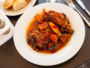 Hot stew of chicken pieces with vegetables and onions with broth
