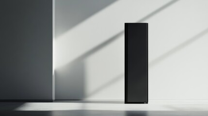 A black, rectangular speaker stands in a white room with sunlight streaming through the window, casting shadows on the wall.