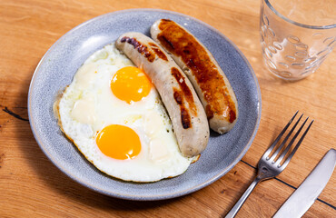 Appetizing fried eggs with sausage served on plate for breakfast