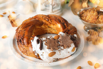 Plate with tasty Christmas pastry wreath and Kutya on light background