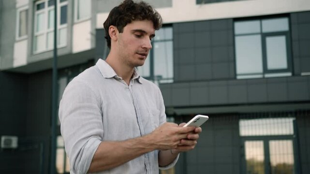Caucasian man walking going street using mobile phone smartphone texting chatting online communication employee male guy message businessman business city outdoor work e-business social media internet