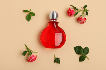 Composition with red bottle of perfume and roses on beige background