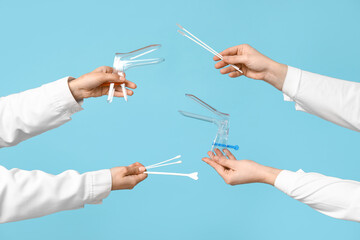Doctor's hands with pap test tools on blue background © Pixel-Shot