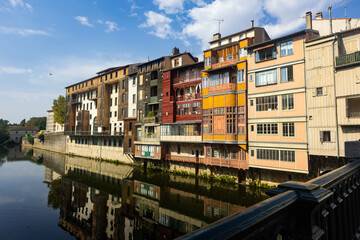 Obraz premium View from bridge of Castres townscape overlooking old colorful houses along Agout river on sunny summer day, Tarn department France