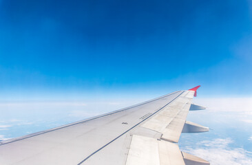 Obraz premium View from the airplane window at a beautiful cloudy sky and the airplane wing