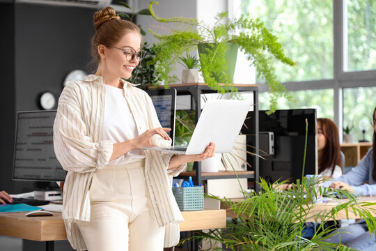 Female programmer working with laptop in office