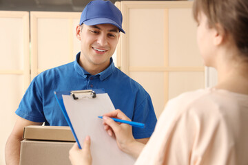 Delivery man giving parcel to woman at doorway