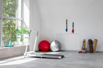Interior of gym with fitballs, fitness mats and treadmill