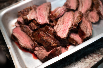 Medium rare pieces of meat resting in plate