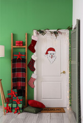 Stylish door decorated for Christmas celebration in room