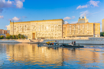 A barge with a tugboat floats along the Moscow River