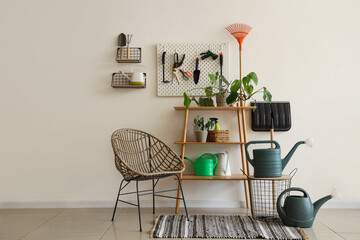 Interior of workshop with gardening tools, pegboard and armchair