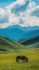 Obraz premium A serene landscape featuring a horse grazing in a lush green valley with mountains in the background.
