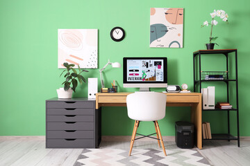 Interior of designer's office with workplace, shelf unit and drawers