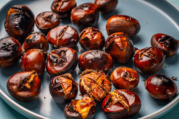 Roasted chestnuts on a blue plate. Close-up. View from above. High quality photo