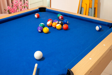A classic moment frozen in time: a pool player's perspective, focused on the white cue ball just moments before it strikes the rack