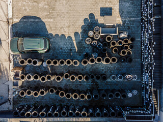 Drone view of car and piles on tires at tire workshop in yard.
