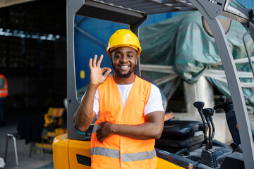 Happy diverse forklift driver gesturing okay for on time shipment.