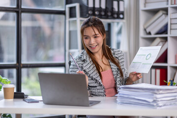 Portrait successful businesswoman, asian woman shows a report of financial documents online interlocutors in the laptop screen, an employee inside an office building online video conference.
