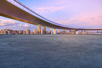 Fototapeta premium Asphalt road square and bridge with city skyline at sunset in Shenzhen. car advertising background.