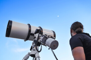 Stargazing with telescope.A person observes the night sky through a telescope, focusing on the...