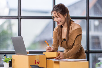 Startup girl Small SME business owners work with laptop computers at work. with parcel paper boxes for delivery to customers online selling, Ecommerce,
