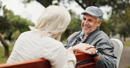 Fototapeta premium Mature couple, talking and smile in park for bonding, conversation and commitment together outdoors. Retirement, marriage and elderly man and women in nature on bench for love, care and connection