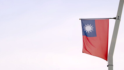 Taiwan flag waving gracefully against a clear sky with empty copy space for text