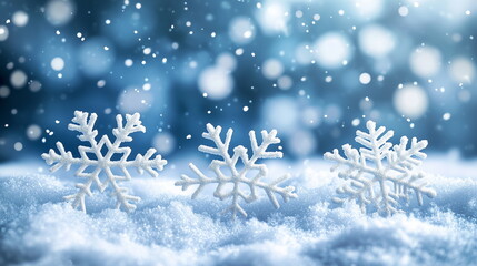 A dark snowy night background. Close-up of three snowflake-shaped ornaments on piled snow. Winter, season, landscape, Christmas, X-mas, year-end, new year, holiday, decoration, background.