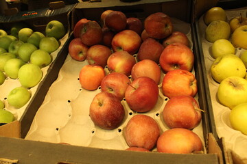 red and green apples in the store in cardboard boxes. Selling and buying fruit in the store