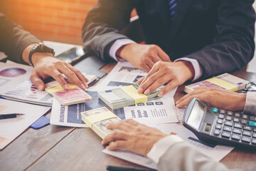 Businesspeoples holding USD dollars, yuan RMB, Euro money sharing for exchange investment. Selected...