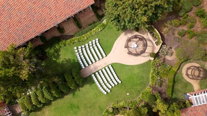An aerial drone shot captures a wedding setup on a lush green lawn, perfect for sunny summer days in California or Florida, evoking love and happiness during this special celebration of marriage