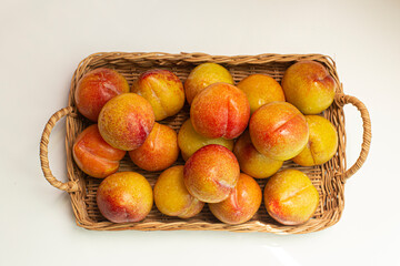 basket of fresh plums isolated on white.