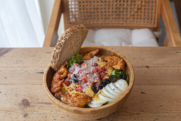 Healthy salad wood bowl with various vegetables, chicken.