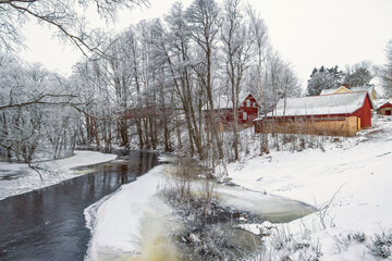 River with ice by a village in a wintry landscape