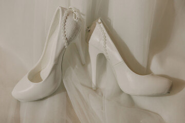 Two white shoes with a heart on the front. The shoes are very pretty and elegant