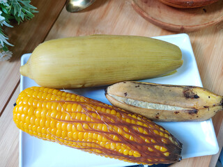 Traditional dish consists of boiled corn on the cob with husk, boiled corn Without husk but with Silky tassels and boiled banana. Healthy food concept 