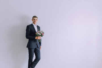 A man in a suit holding a bouquet of flowers. Concept of elegance and sophistication, as the man is...
